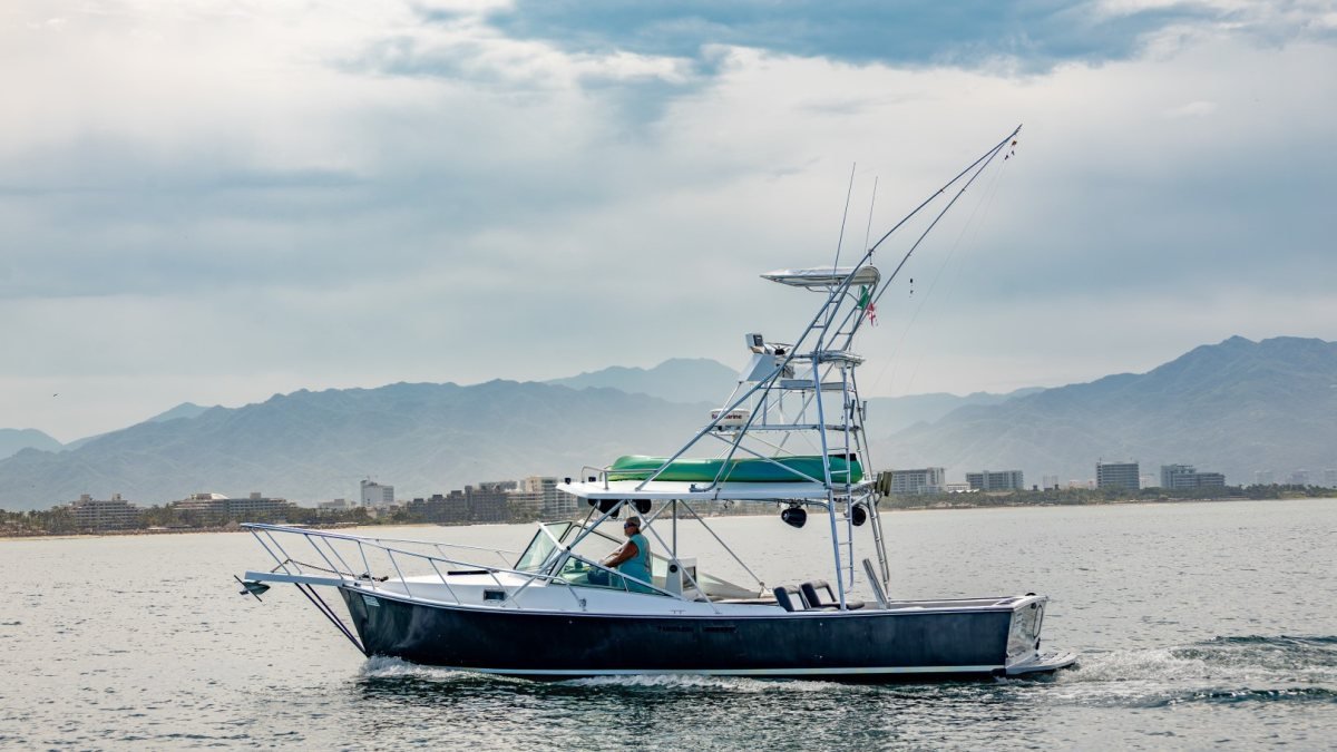 Guanatuna, 34-foot Gulfstream sport fishing boat off Nuevo Vallarta with the hotel zone behind